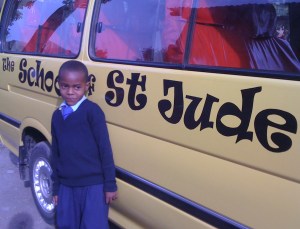 8-year-old Kelvin Mushi walks down a long, bumpy road to reach his bus stop along the highway.