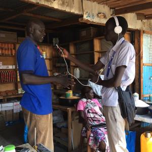 Mingkaman 100 FM Bor reporter Chan Amol interviews a trader at Marol market in Bor town.